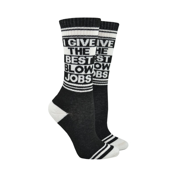 Shown on leg forms, a pair of black cotton Gumball Poodle brand unisex crew socks with white striped cuff/heel/toe. These socks feature the phrase, "I GIVE THE BEST BLOW JOBS" in alternating black and white font.