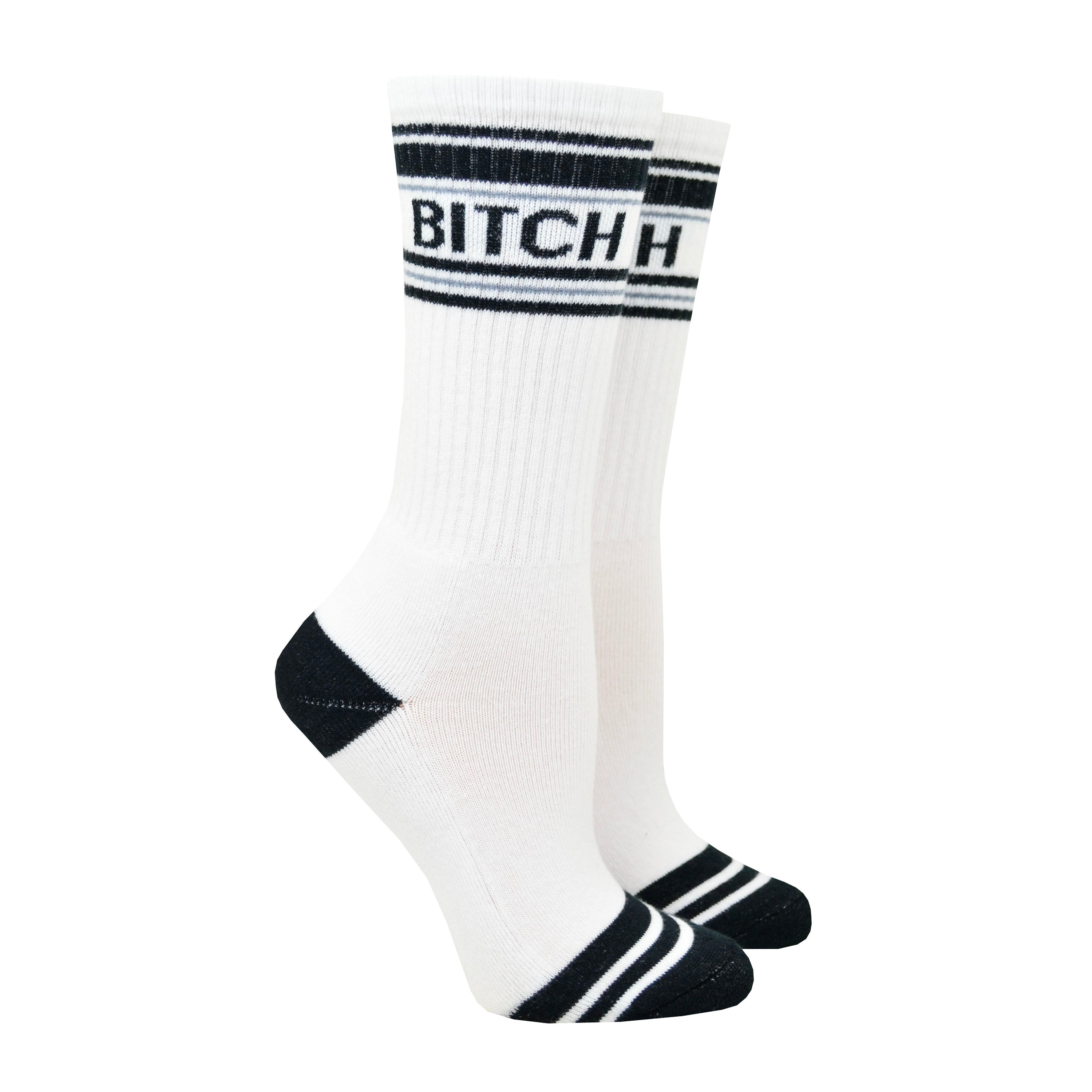 Shown on a leg form, these white cotton unisex crew socks with a black toe and striped cuff by the brand Gumball Poodle feature the words 