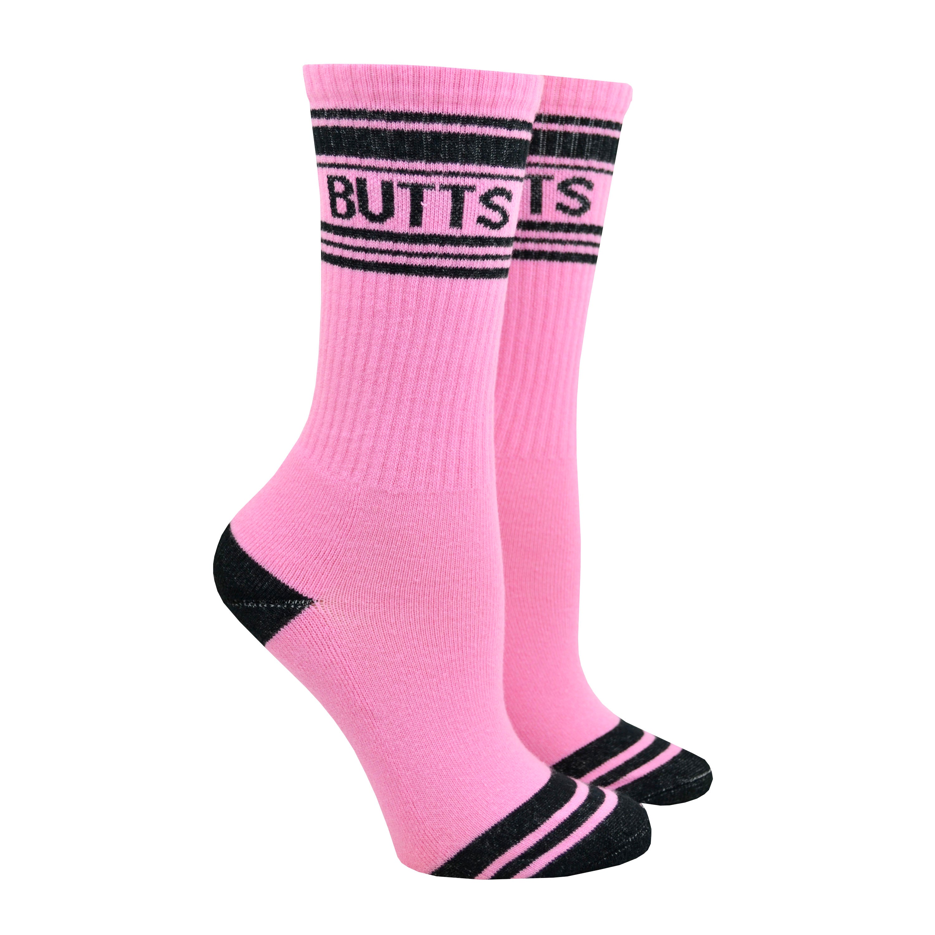 Shown on a leg form, these pink cotton unisex crew socks with a black striped toe and cuff by the brand Gumball Poodle feature the word 