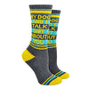 Shown on a leg form, these gray cotton unisex crew socks with a yellow toe and yellow and blue striped cuff by the brand Gumball Poodle feature the words "MY DOG AND I TALK SHIT ABOUT YOU" on the leg.