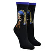 Shown on leg forms, a pair of women's Hot Sox brand cotton crew socks in black with a blue cuff. These socks feature the iconic Johannes Vermeer painting 'The Girl with a Pearl Earring' and a 3D pearl detail.