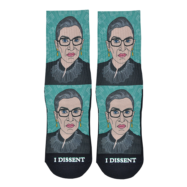 Shown in a flatlay, a pair of Good Luck Socks brand unisex green polyester and cotton crew socks. The front of these socks features a caricature of the iconic Supreme Court Justice Ruth Bader Ginsburg in one of her well-known collars with the words 