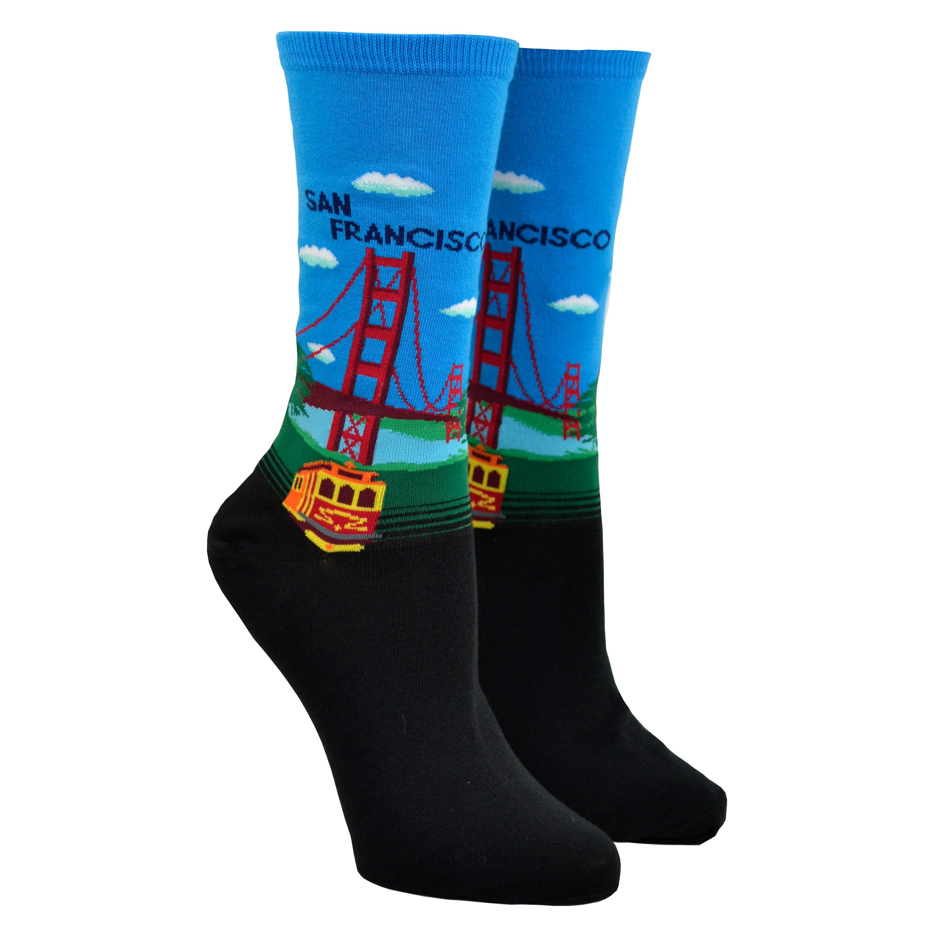 Shown on a leg form, a pair of Hot Sox cotton women’s crew socks with Golden Gate Bridge, hills, trolley and light blue sky