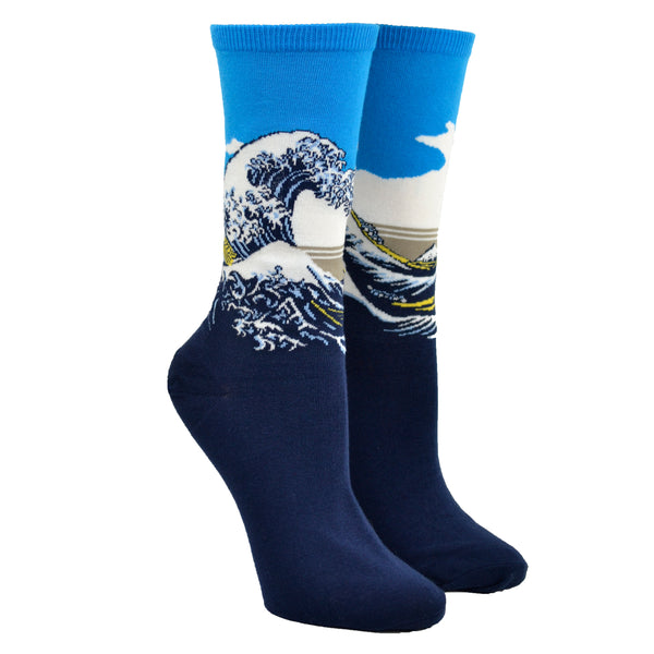 Shown on a leg form, these blue cotton women's crew socks by the brand Hot Sox feature the famous print The Great Wave by the Japanese artist Hokusai.
