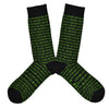 Shown in a flatlay, a pair of K. Bell’s black cotton men’s crew socks with green 1s and 0s