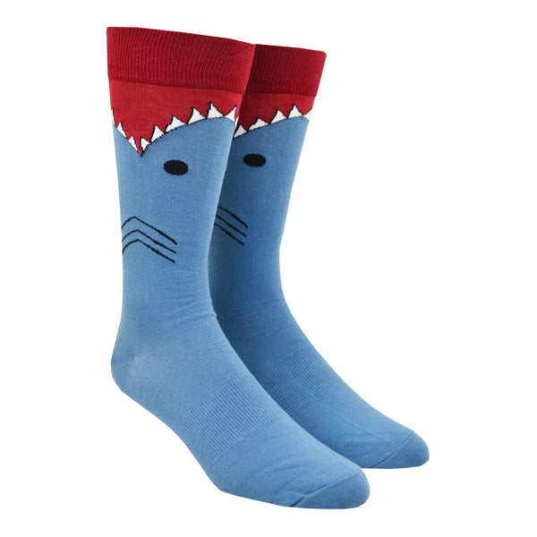 Shown on a leg form, these blue cotton men's novelty crew socks with a red top and cuff by the brand K Bell make it look like a shark is eating your leg, showing the sharks gills, eyes and teeth chomping on your calf.