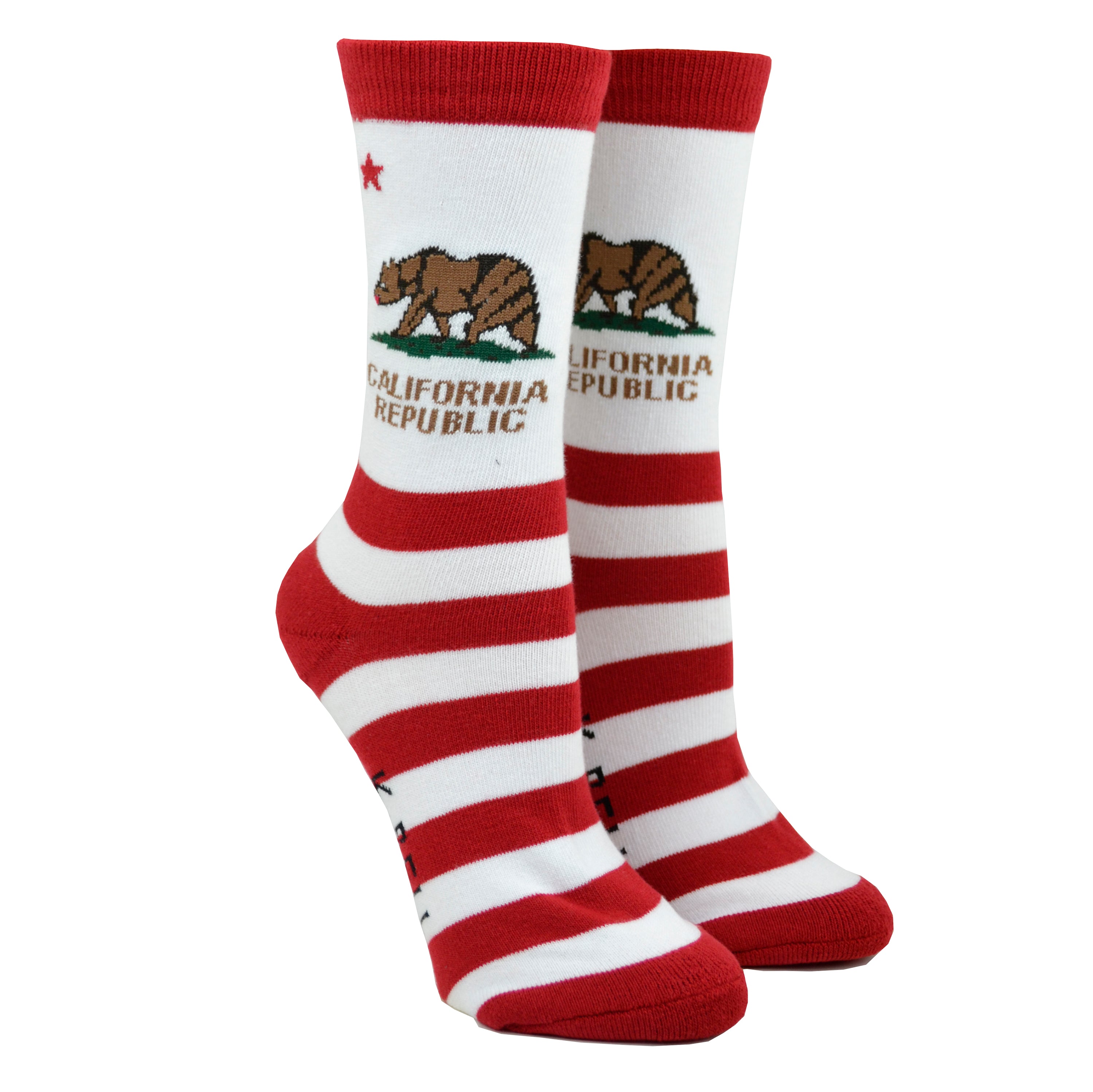 Shown on a foot form, a pair of K. Bell white cotton women's crew socks with red stripes, brown bear and “California Republic” text, reminiscent of the California flag