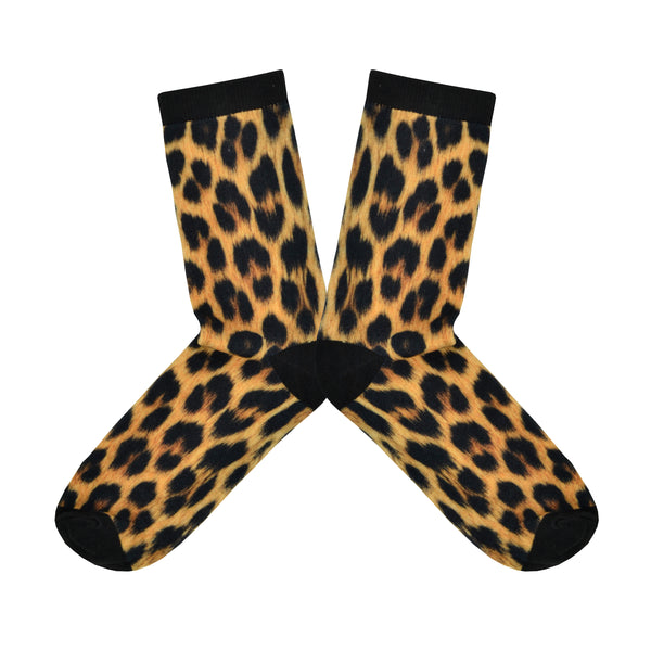 Shown in a flatlay, a pair of women's crew socks with a black heel, toe, and cuff that feature an all over leopard print in the classic black/orange/tan colors.