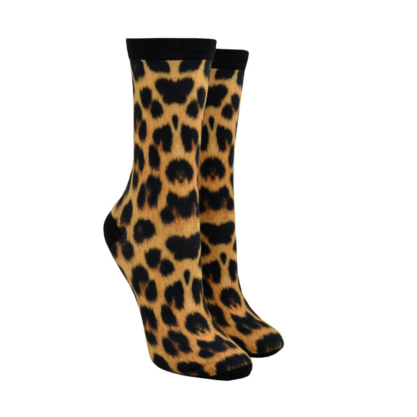 Shown on leg forms, a pair of women's crew socks with a black heel, toe, and cuff that feature an all over leopard print in the classic black/orange/tan colors.