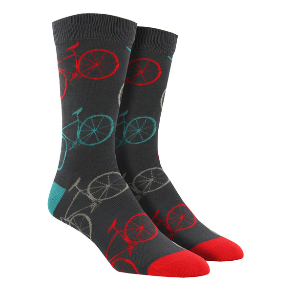 Shown on a leg form, a pair of Socksmith's bamboo men's crew socks in gray with simple bicycles on them