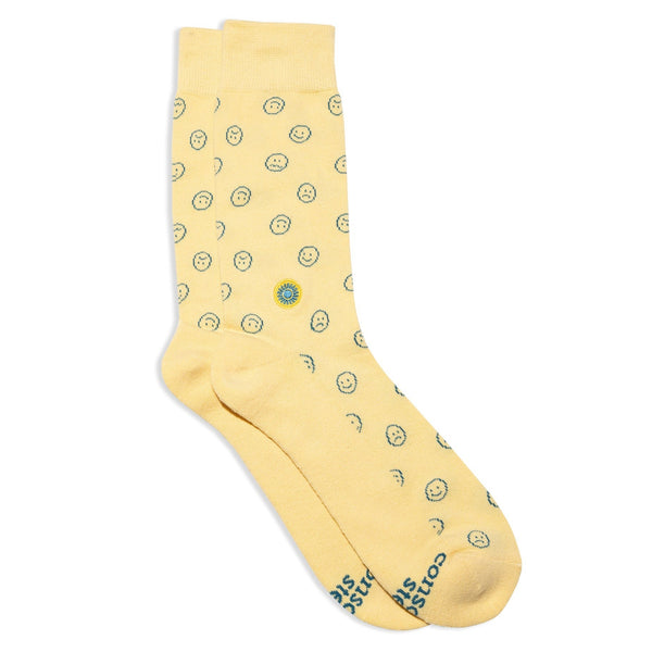 flatlay of yellow crew length socks with small blue happy and sad faces