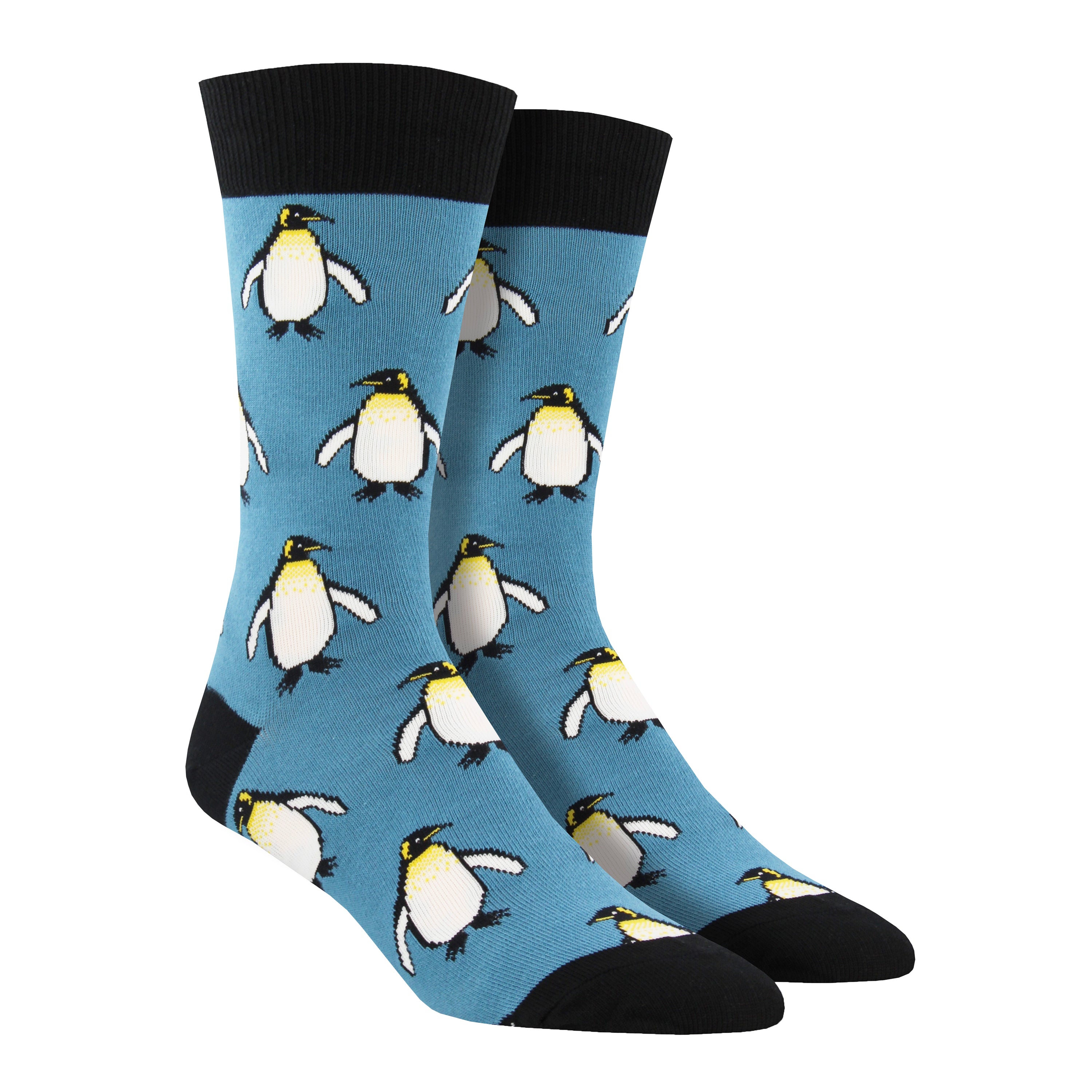 Shown on a foot form, a pair of Socksmith's blue cotton men's crew socks with black cuff/heel/toe and all-over pattern regal emperor penguins