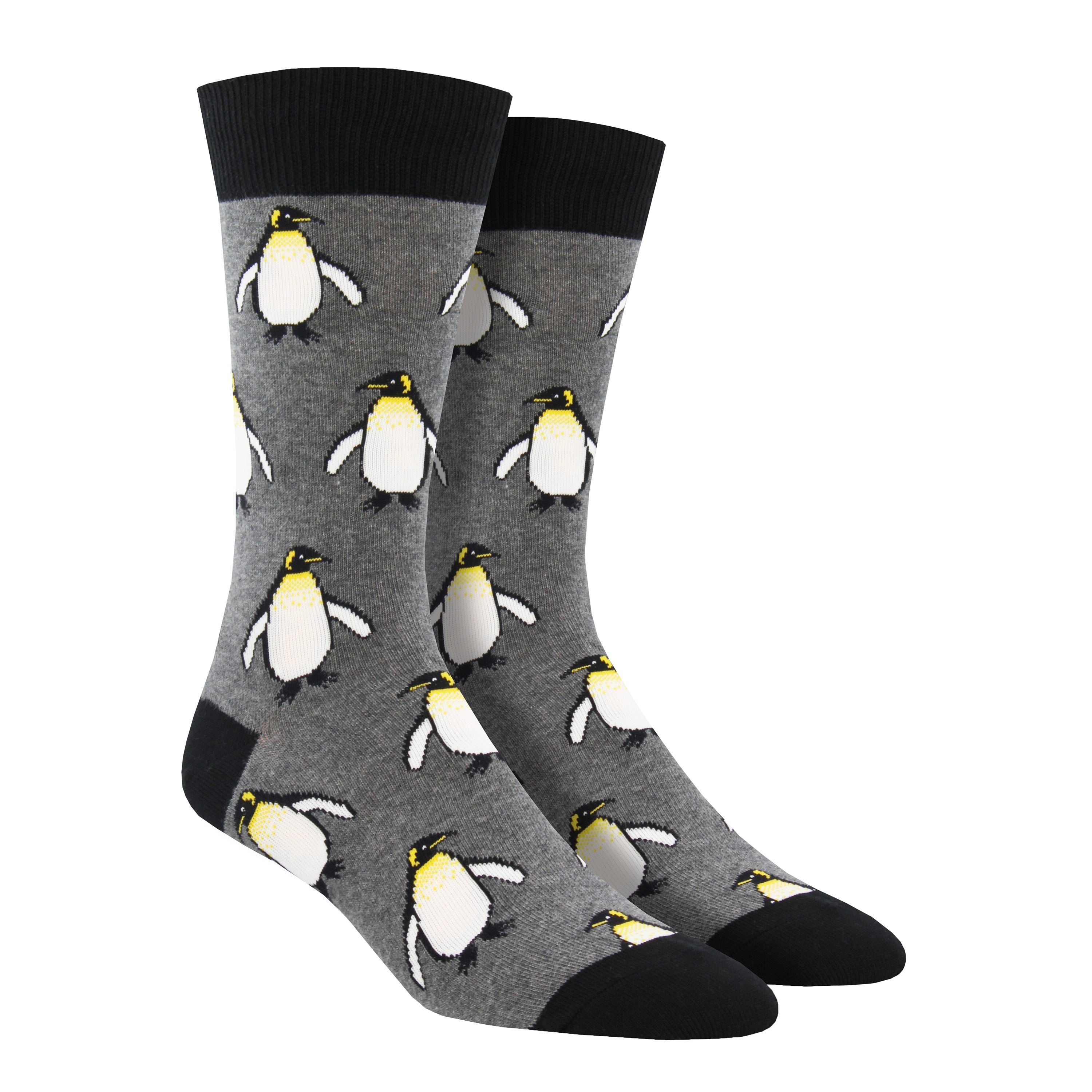 Shown on a foot form, a pair of Socksmith's gray cotton men's crew socks with black cuff/heel/toe and all-over pattern regal emperor penguins