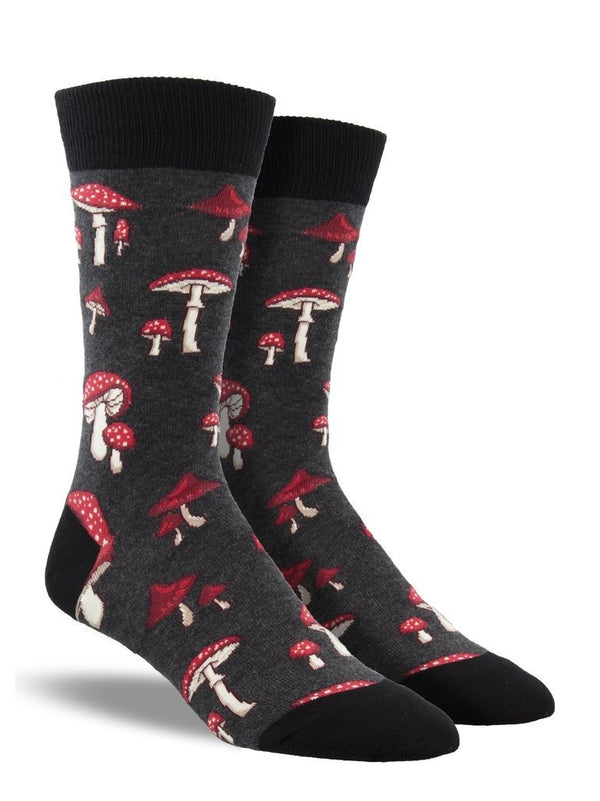 Shown on a leg form, these heather grey cotton men's crew socks by the brand Socksmith feature cute little mushrooms with red caps and white spots.