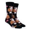 Shown on footforms, a pair of Socksmith men's black cotton crew socks with black cuff/heel/toe featuring an all over design of a monkey in a suit and tie.