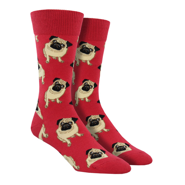Shown on a foot form, a pair of Socksmith's light red cotton men's crew socks with yellow pugs in an all-over pattern