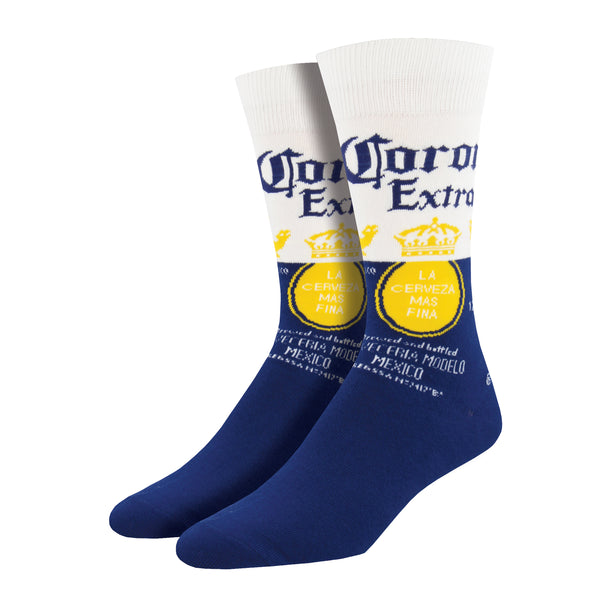 Shown on a foot form, a pair of Socksmith's cotton men's crew socks with Corona beer logo and signature navy blue and white background