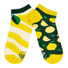 A pair of unisex Many Morning mismatched cotton ankle socks are shown in a flat position displaying a lemon peel design on one sock and whole and cut lemons on the other style.