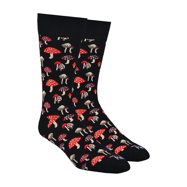 Shown on a foot form, a pair of MeMoi's black bamboo men's crew socks with various small mushrooms in an all over pattern