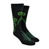 Shown on a foot form, a pair of Mod Socks’ black cotton men's crew socks with green ferns and fiddleheads
