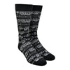 A black cotton Men's crew sock by Modsock is shown on a mannequin foot form featuring a sheet music design from its top to bottom. 