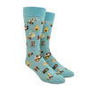 Shown on a foot form, a pair of Mod Socks’ pale blue cotton men's crew socks with all-over pattern of various camera models