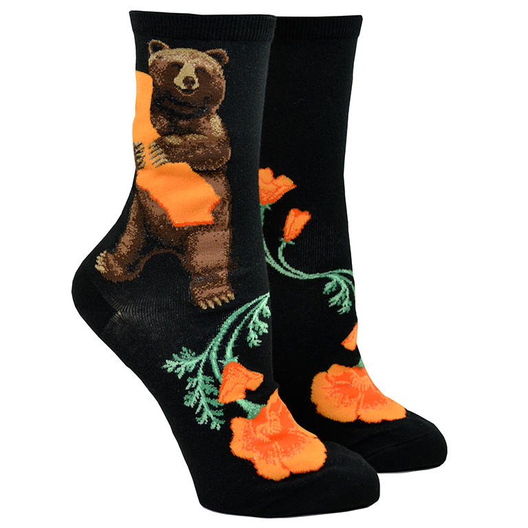 Shown on a foot form, a pair of Mod Socks’ black cotton women's crew socks with cute brown bear hugging orange California map, surrounded by orange poppies