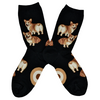 Shown in a flatlay, a pair of Mod Socks brand women's cotton crew socks in black. The sock features an all over motif of blonde  corgi dogs with their little heart shaped butts facing out.