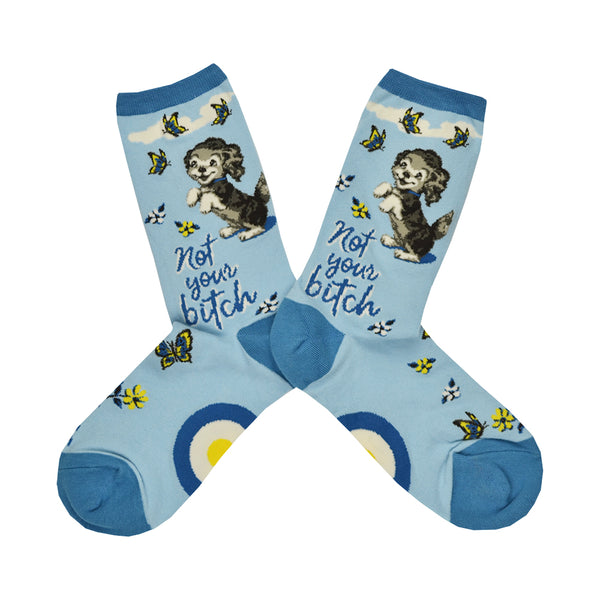 These blue cotton women's crew socks feature an adorable puppy sweetly smiling with dainty yellow flowers and butterflies throughout and the text "Not Your Bitch" written on the leg.