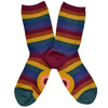 Shown in a flatlay, a pair of women's cotton crew socks by ModSocks. These socks feature a muted rainbow stripe in red, burnt orange, matte gold, emerald green, dark blue, and purple.