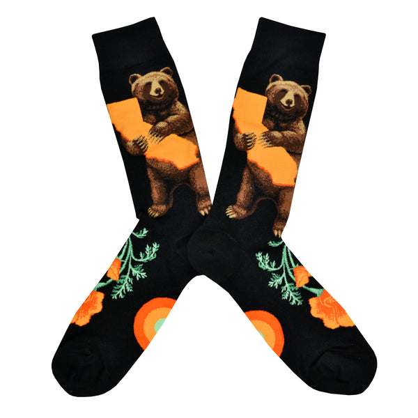 These black cotton men's crew socks by the brand Mod Socks feature a bear standing and hugging a large orange sketch of the state of California, and orange California poppy's on the foot.