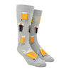 Shown on a foot form, a pair of Mod Socks’ gray cotton men's crew socks with  various steins of foamy beer