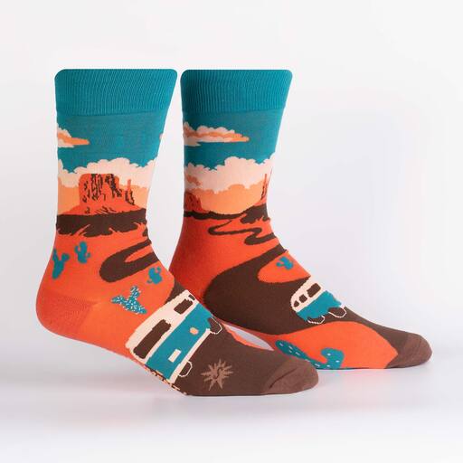 A pair of sock it to me cotton socks on leg forms featuring a scene of Monument Valley National Park, with clouds in the sky and a Volkswagon van in the foreground.