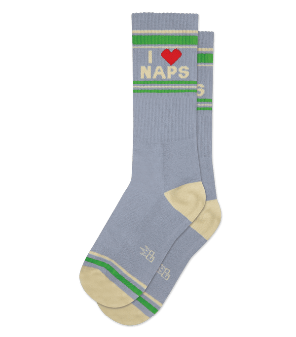 In flatlay, a gray pair of socks with tan heels, tan and green stripe patterns at the top and toe, and text that reads "I [Red Heart Icon] Naps"