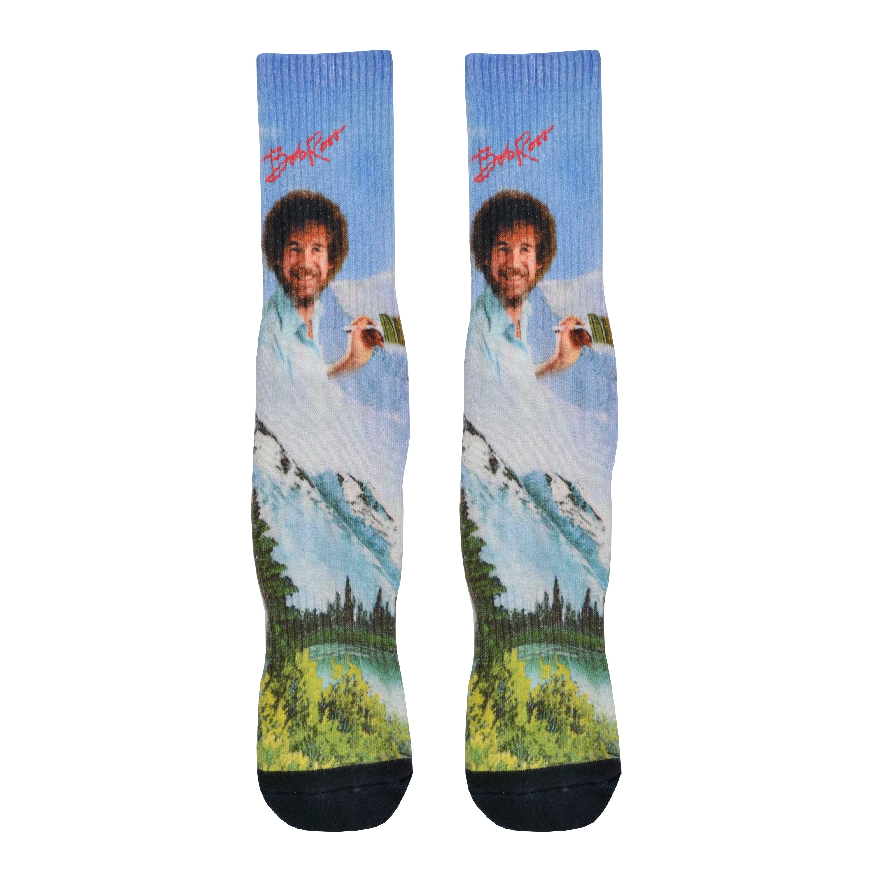 Shown in a flatlay, a pair of Oooh Yeah’s cotton men’s crew socks with light blue nature-scape and Bob Ross portrait