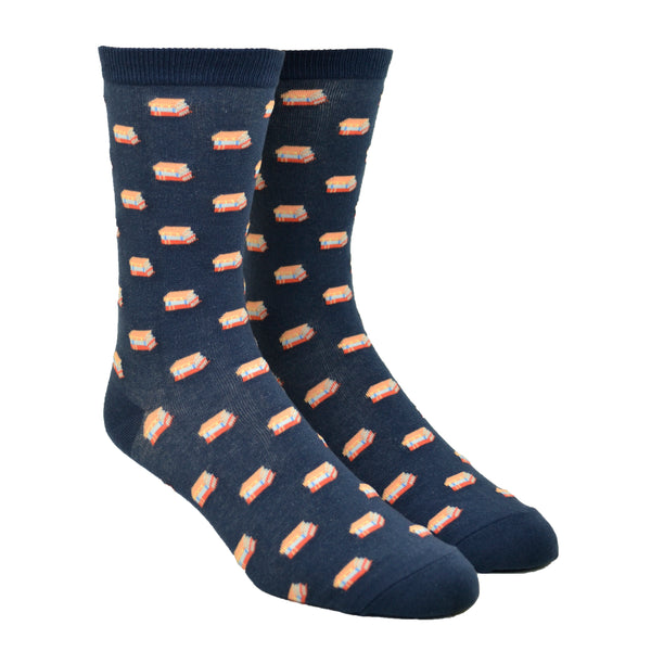 Shown in the large size on leg forms, a pair of unisex Out of Print brand cotton crew sock in navy blue with an all over motif of little stacks of books.