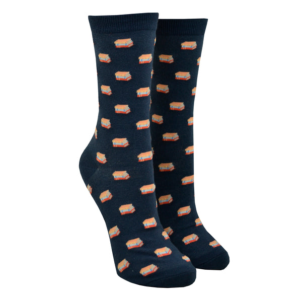Shown in the small size on leg forms, a pair of unisex Out of Print brand cotton crew sock in navy blue with an all over motif of little stacks of books.