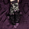 A lush purple textured background displays a models feet wearing the Edgar Allan Poe socks.