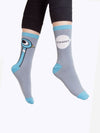 Shown on a foot model, a pair of unisex Out of Print gray cotton crew socks with illustrated pigeon cartoon on outside of ankle