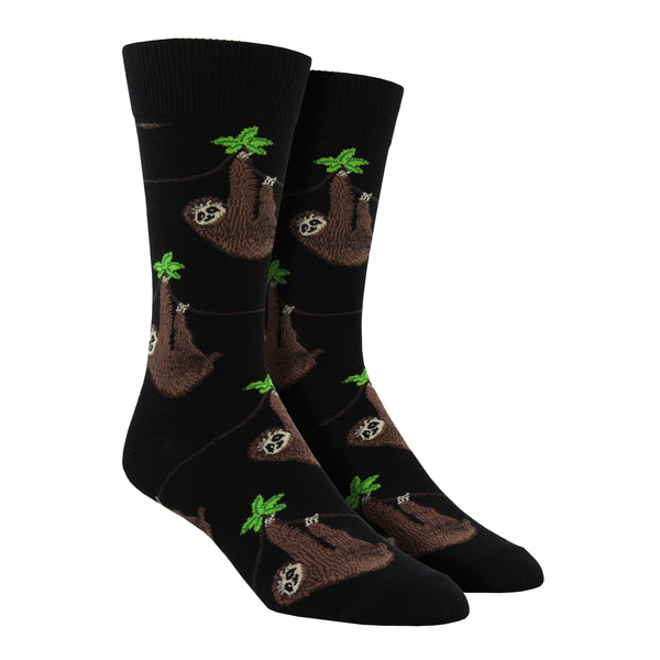 Shown on a foot form, a pair of Socksmith's black cotton men's crew socks with chill sloths hanging from vibes