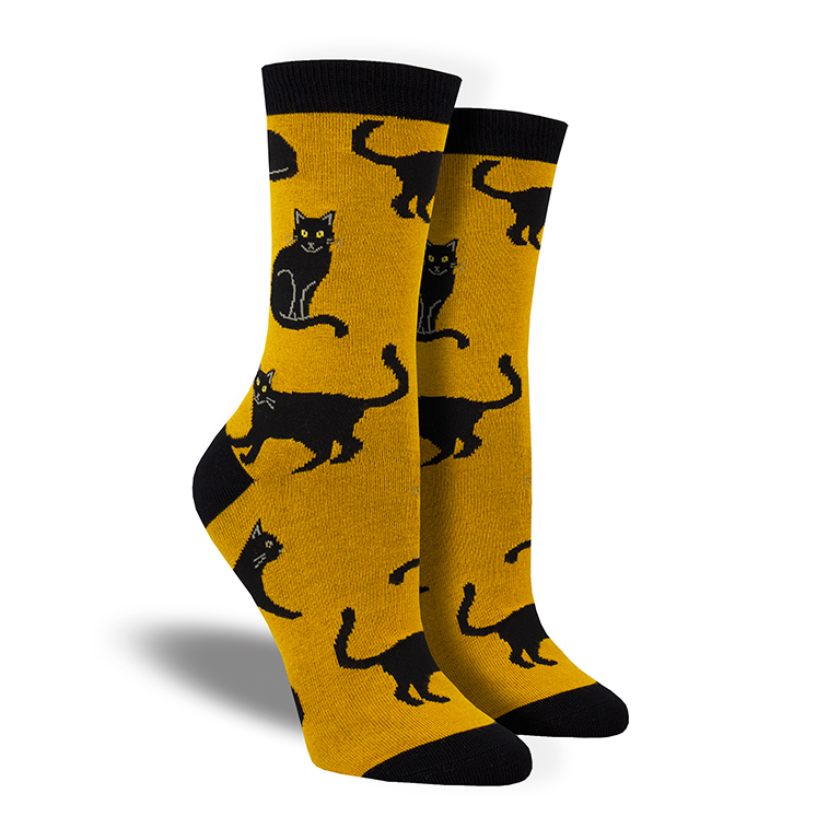 Shown on leg forms, a pair of Socksmith brand women's bamboo crew socks in matte gold with a black heel, toe, and cuff. This sock features an all over design of black cats.