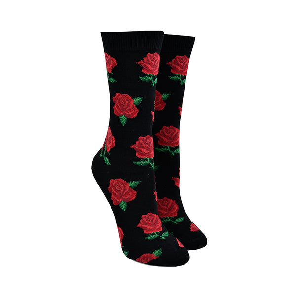Shown on leg forms, a pair of Socksmith brand women's bamboo crew socks in black. This sock has an all over motif of red roses with green leaf accents.