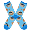 Shown in a flatlay, a pair of Socksmith’s blue cotton women’s crew socks with various cats sitting in cardboard boxes
