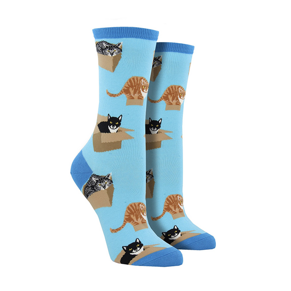 Shown on a leg form, a pair of Socksmith’s blue cotton women’s crew socks with various cats sitting in cardboard boxes