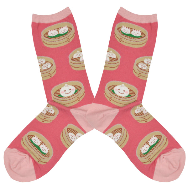 Shown in a flatlay, a pair of SockSmith brand women's cotton crew socks in pink with a pastel pink heel, toe, and cuff. The sock features different dumplings in bamboo steamers with little smiles on them.