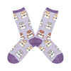 Shown in a flatlay, a pair of women's Socksmith brand cotton and nylon crew sock in lilac with a purple heel, toe, and cuff. These socks feature an all over pattern of grey, blonde, and brown hamsters holding a little sunflower seed.