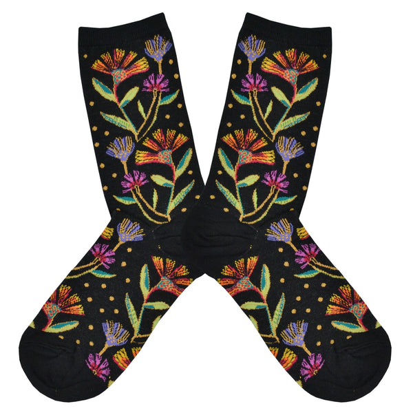 These black cotton women's crew socks by Socksmith feature the artwork of Laurel Burch and have pink, purple and orange flowers woven with metallic threads all over the leg and foot.