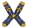 Shown in a flatlay, a pair of Socksmith's bamboo men’s crew socks with mustard-yellow cuff/heel/toe and a spooky skeleton woman with a Madonna halo