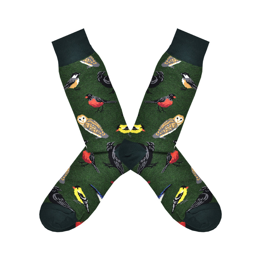 Shown in a flatlay, a pair of Socksmith's dark green cotton men’s crew socks with wild North-American bird pattern