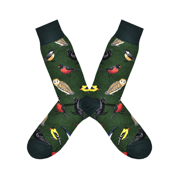 Shown in a flatlay, a pair of Socksmith's dark green cotton men’s crew socks with wild North-American bird pattern